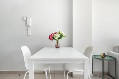a white dining room table with a vase of flowers at Supreme C2 Apartment in Syntagma in Athens