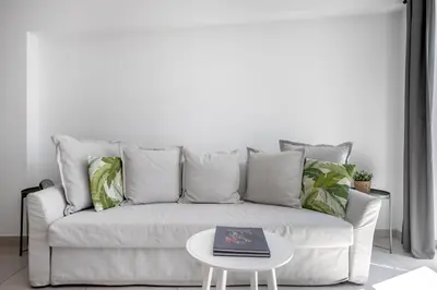 a living room with a white couch with a table at Supreme C2 Apartment in Syntagma in Athens