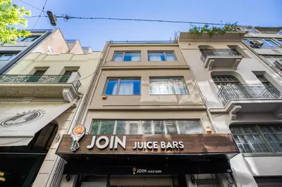 a building with a jon juana juice bars sign on it at Supreme C2 Apartment in Syntagma in Athens