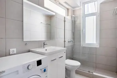 a white bathroom with a sink and a toilet at Supreme C2 Apartment in Syntagma in Athens