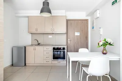 a kitchen with a white table and white chairs at Supreme C2 Apartment in Syntagma in Athens