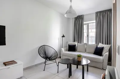 a white living room with a couch and a table at Supreme B2 Apartment in Syntagma in Athens