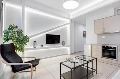 a living room with a black chair and a glass table at Supreme B1 Apartment in Syntagma in Athens