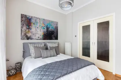 a bedroom with a bed with a painting on the wall at Acropolis Stylish Suite in Athens