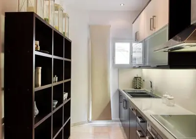 a kitchen with black cabinets and a sink at Acropolis Stylish Suite in Athens