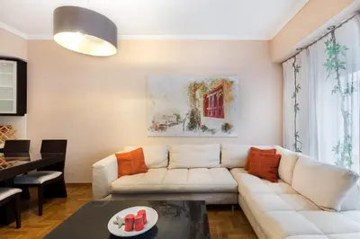 a living room with a white couch and a table at Acropolis Stylish Suite in Athens