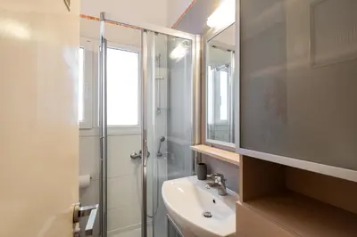 a white bathroom with a sink and a shower at Acropolis Stylish Suite in Athens