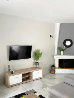 a living room with a flat screen tv on a wall at Aggelikis House in Spáta