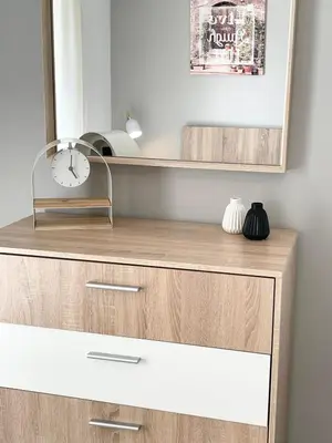 a wooden dresser with a clock and a mirror at Aggelikis House in Spáta