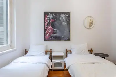 two twin beds in a room with white walls at Plaka Vintage in Athens