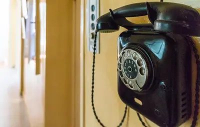 a black phone is hanging on a wall at Plaka Vintage in Athens