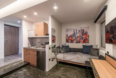 a kitchen with a couch in the middle of a room at AthinA STREETAPARTMENTS in Athens