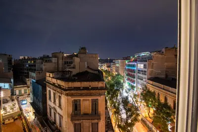 a view of a city at night with buildings at AthinA STREETAPARTMENTS in Athens