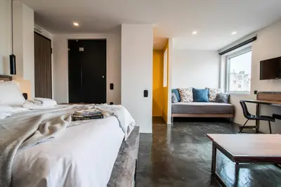 a bedroom with a bed and a couch and a table at AthinA STREETAPARTMENTS in Athens