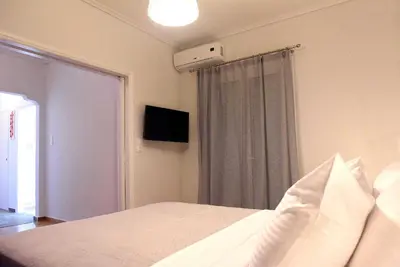 a bedroom with a white bed and a window at Pnyka Apartment 1 in Athens