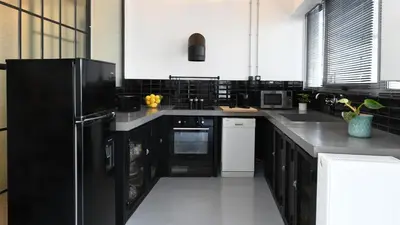 a kitchen with black cabinets and a black refrigerator at Monastiraki #WallsFree CityCenter- Unspoiled Athens Apartments in Athens
