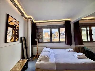 a bedroom with a bed in a room with windows at Monastiraki #WallsFree CityCenter- Unspoiled Athens Apartments in Athens