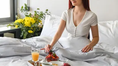 a woman sitting in bed with a bowl of fruit at Monastiraki #WallsFree CityCenter- Unspoiled Athens Apartments in Athens