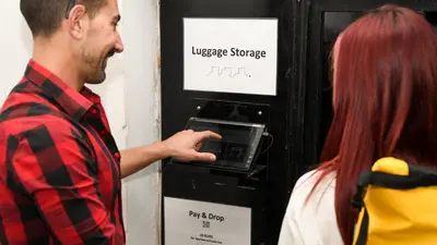 a man is putting money in a dispensing machine at Monastiraki #WallsFree CityCenter- Unspoiled Athens Apartments in Athens