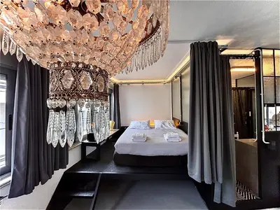 a bedroom with a bed and a chandelier at Monastiraki #WallsFree CityCenter- Unspoiled Athens Apartments in Athens