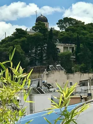 a view of a building with a dome on a hill at Stylish penthouse with Acropolis and 360 view in Athens