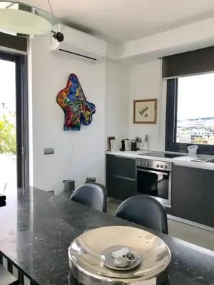 a kitchen with a table and chairs in a room at Stylish penthouse with Acropolis and 360 view in Athens
