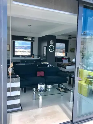 a living room with a couch and a table at Stylish penthouse with Acropolis and 360 view in Athens