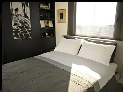 a bedroom with a large bed with a window at Stylish penthouse with Acropolis and 360 view in Athens