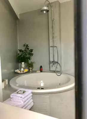 a bathroom with a tub with a mirror and towels at Stylish penthouse with Acropolis and 360 view in Athens