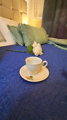 a cup and a saucer on a table with a bed at Apartment near sea Elpida's Edem in Athens