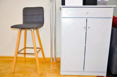 a black stool next to a white cabinet at Mia's cozy flat in Ermou, 3 min from 