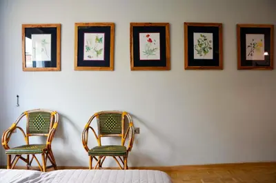 two chairs sitting in front of a wall with pictures at Mia's cozy flat in Ermou, 3 min from 