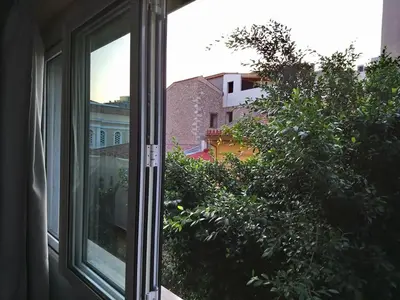 an open window with a view of a tree at Mia's cozy flat in Ermou, 3 min from 