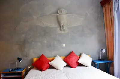 a bedroom with a bed with a bird on the wall at Mia's cozy flat in Ermou, 3 min from 