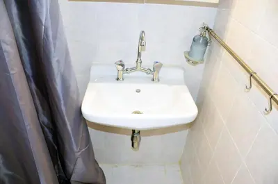 a white sink in a bathroom with a shower at Mia's cozy flat in Ermou, 3 min from 