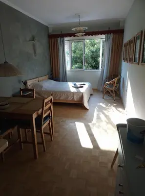 a bedroom with a bed and a table and a dining room at Mia's cozy flat in Ermou, 3 min from 