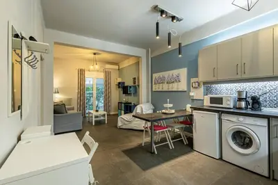 a kitchen and living room with a table and a washing machine at Ruby ' s Best Acropolis Apartment in Athens