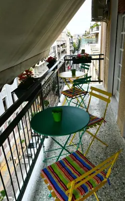 a balcony with tables and chairs on a balcony at Top Koukaki Location 3rd floor 2bdr in Athens