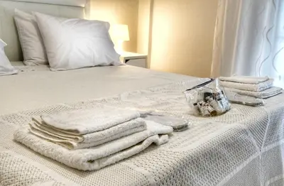 a pile of towels sitting on top of a bed at Top Koukaki Location 3rd floor 2bdr in Athens