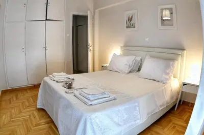 a bedroom with a white bed with towels on it at Top Koukaki Location 3rd floor 2bdr in Athens