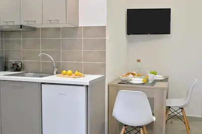 a kitchen with a sink and a counter with a chair at Alekos Apartments 2 Netflix, Self Check-In in Athens