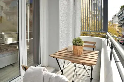 a wooden table on a balcony with a plant at Alekos Apartments 2 Netflix, Self Check-In in Athens