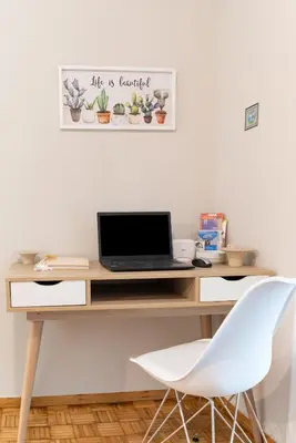 a desk with a laptop and a white chair at Fix Divine Apartment in Athens