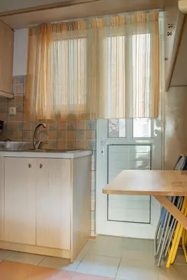 a kitchen with a wooden table and a window at Fix Divine Apartment in Athens