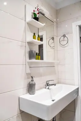 a white bathroom with a sink and a mirror at Fix Divine Apartment in Athens