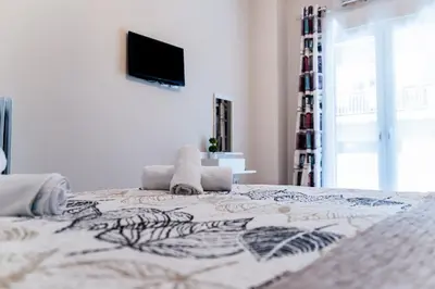 a bedroom with a bed with a television on the wall at Fix Divine Apartment in Athens