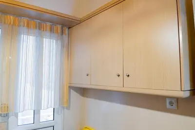 a kitchen with wooden cabinets and a window at Fix Divine Apartment in Athens