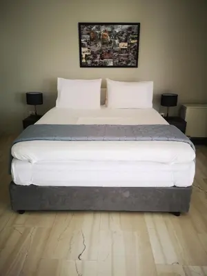 a large bed in a room with two tables at Androniki suite in Athens