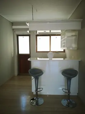 a kitchen with two stools at a counter with two windows at Androniki suite in Athens