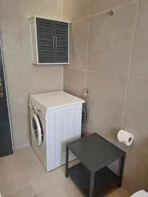 a washing machine in a bathroom with a table at Androniki suite in Athens